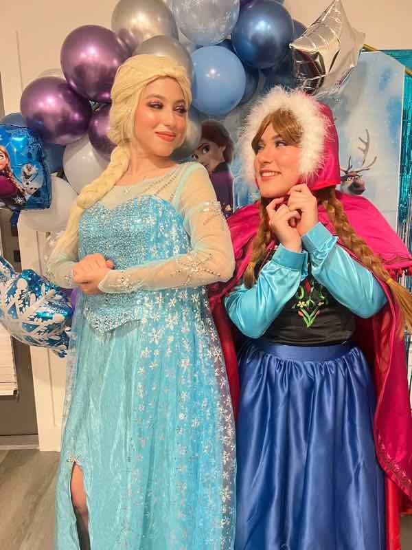 Elsa and Anna characters at a Frozen party